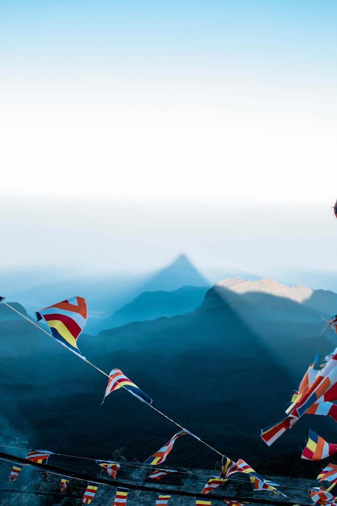 Colorful flags flutter against the backdrop of Sri Lanka's scenic mountain landscape, creating a vibrant contrast.
