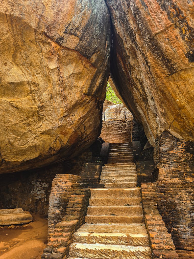 Discover the ancient stone staircase leading through monumental rock formations at Sigiriya, Sri Lanka.