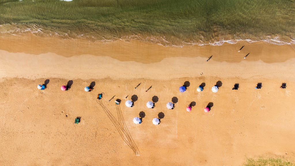 Stunning aerial photo of colorful beach umbrellas on the sandy shores of Bentota, Sri Lanka.