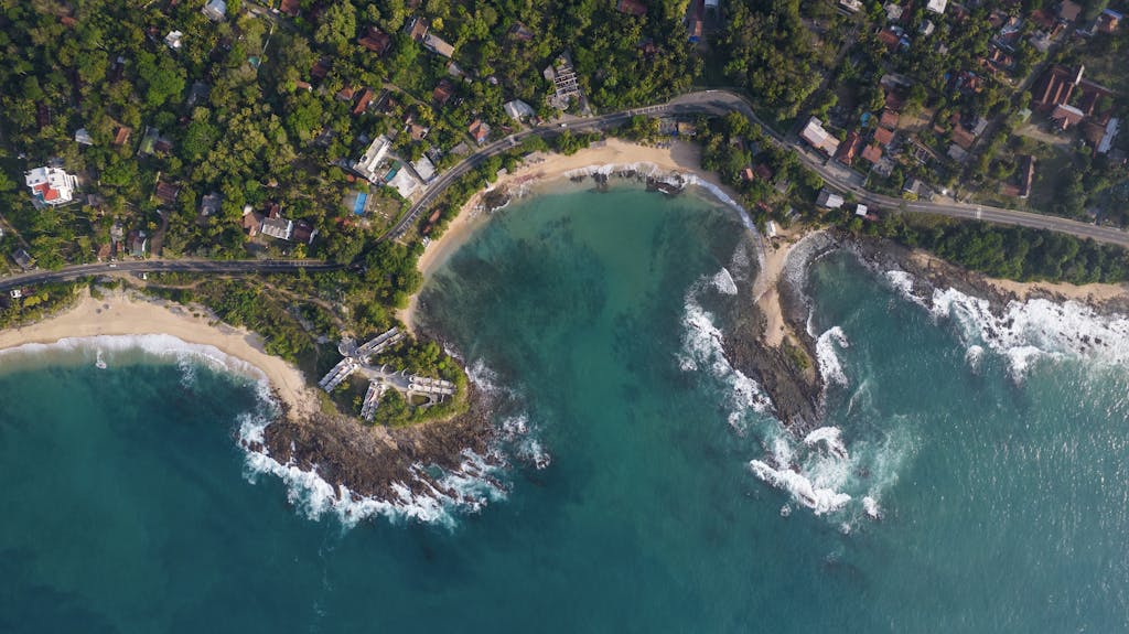 Stunning aerial view of Thangalla Beach, Sri Lanka, showcasing turquoise waters and lush greenery.
