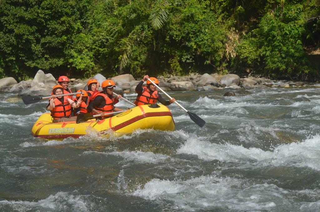Thrilling white-water rafting experience in a lush forest setting with a group of adventurous adults.